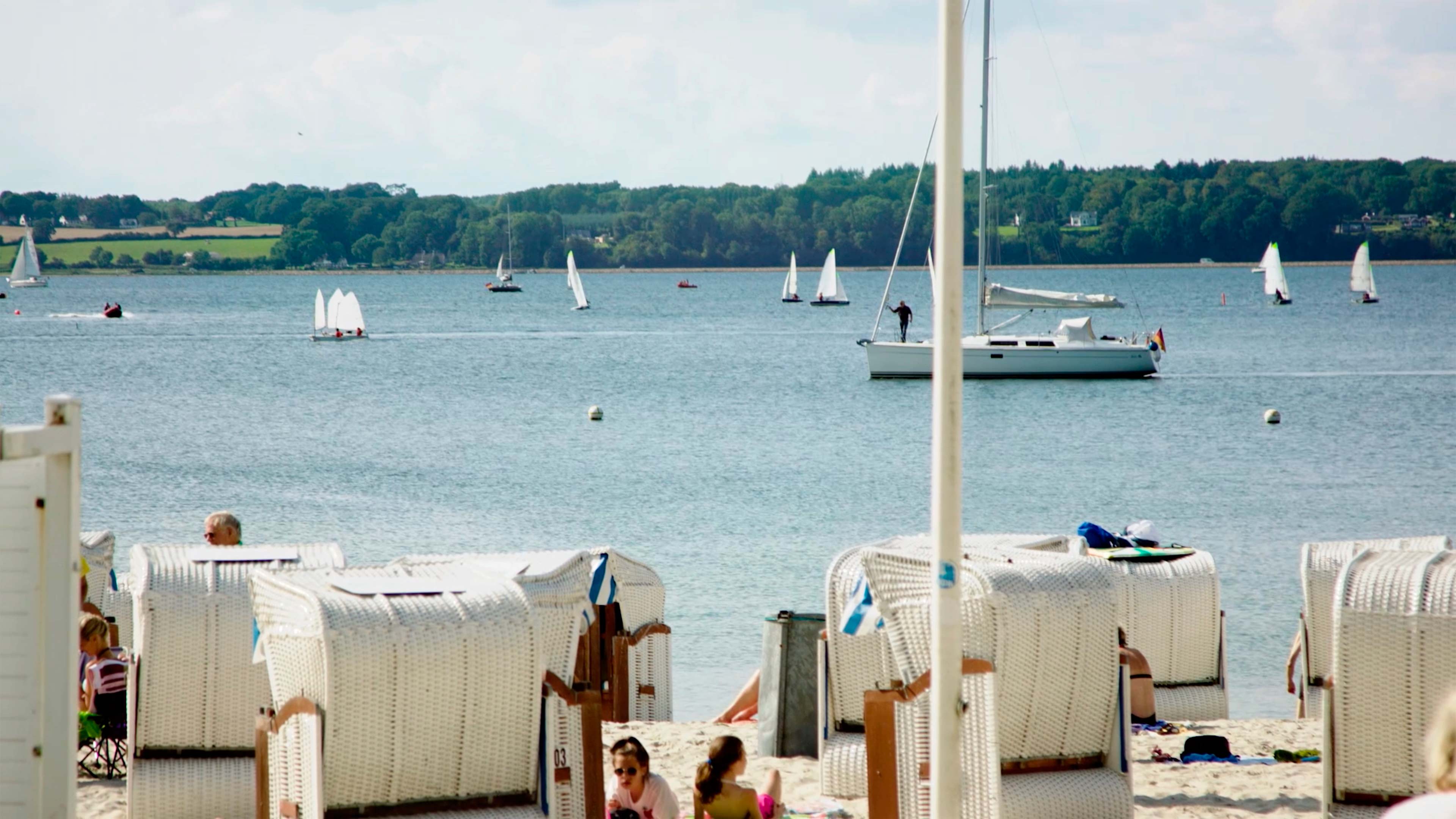 Weiße Strandkörbe stehen am Strand