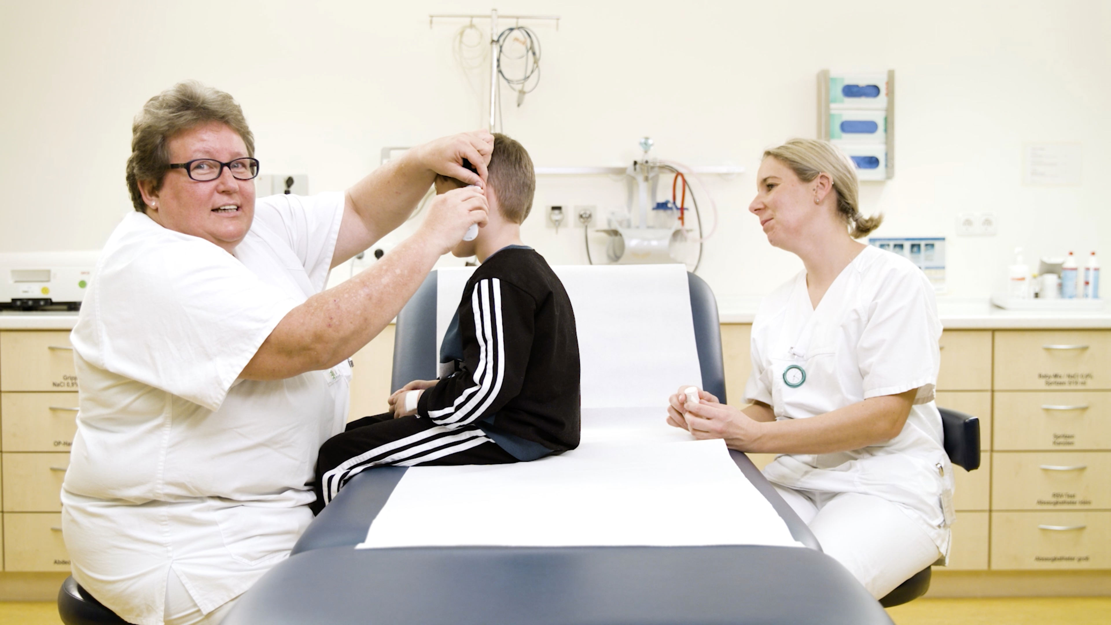 Eine Krankenpflegerin misst die Temperatur eines Kindes
