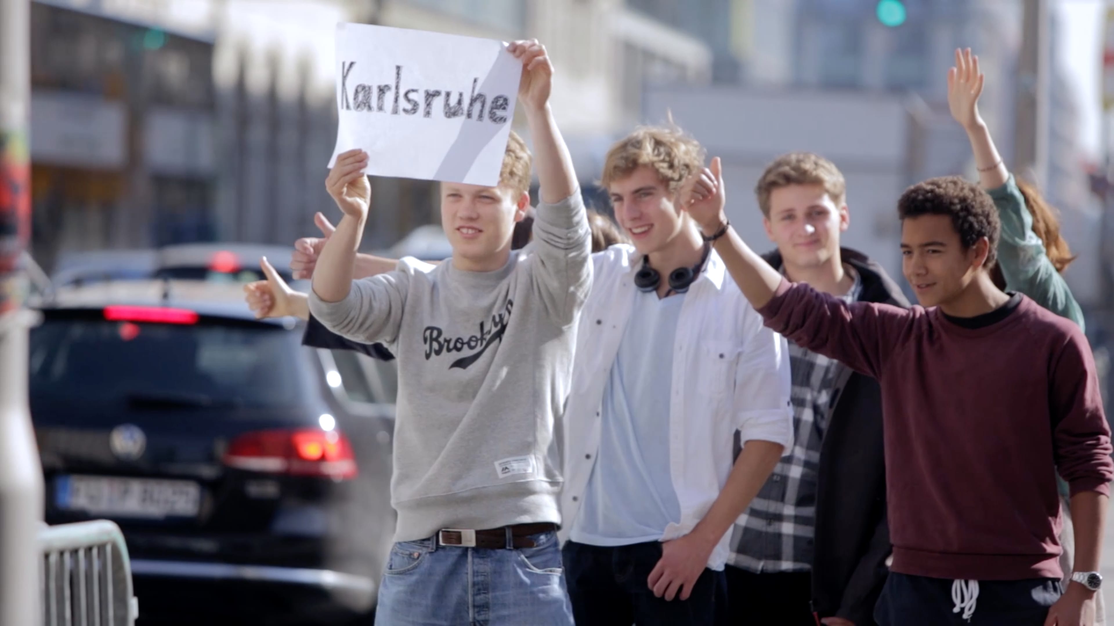 Eine Gruppe Jugendlicher halten ein weißes Papier hoch