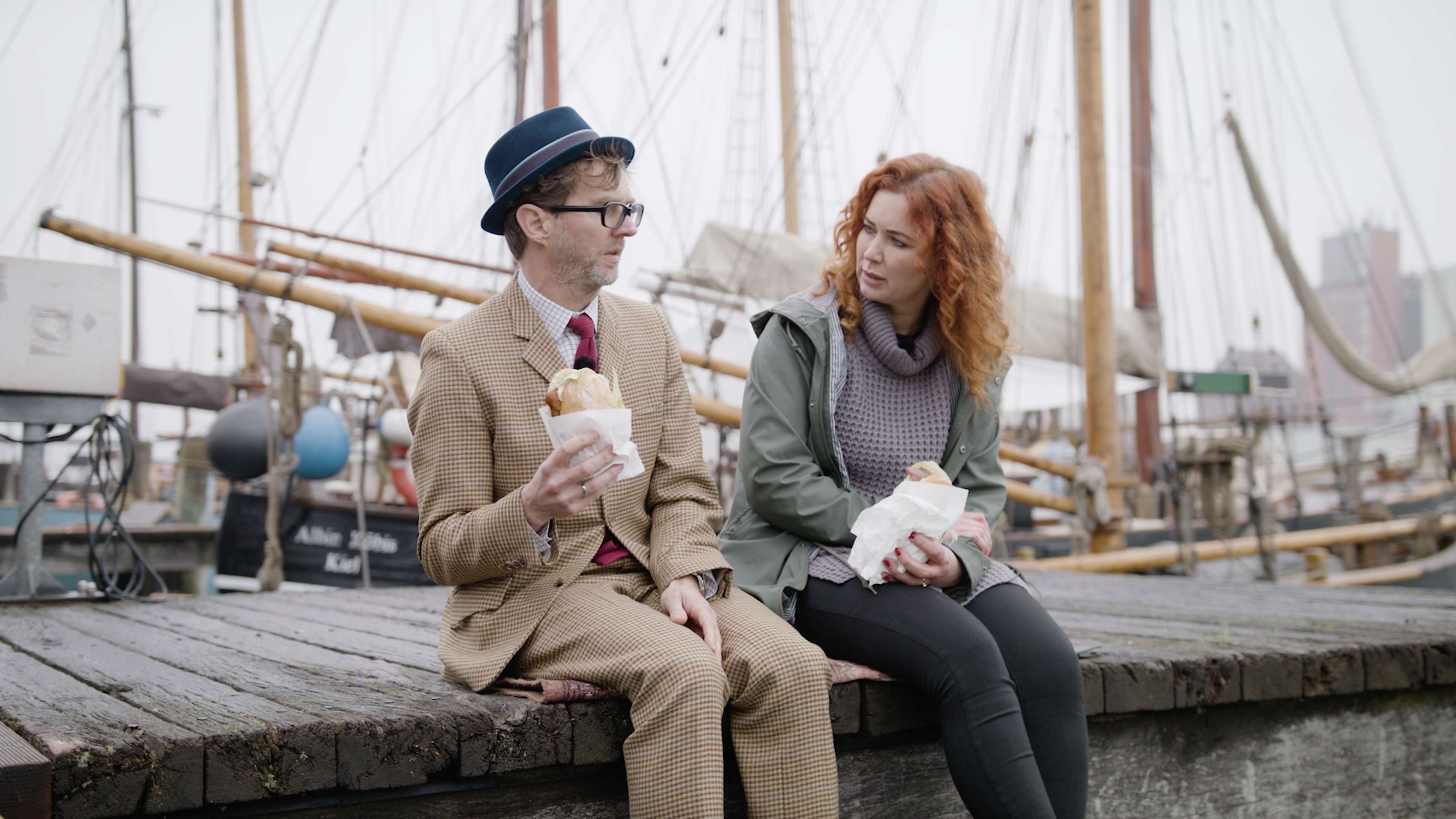 Jim Lacy und Kirsten Hermann sitzen auf Bootssteg